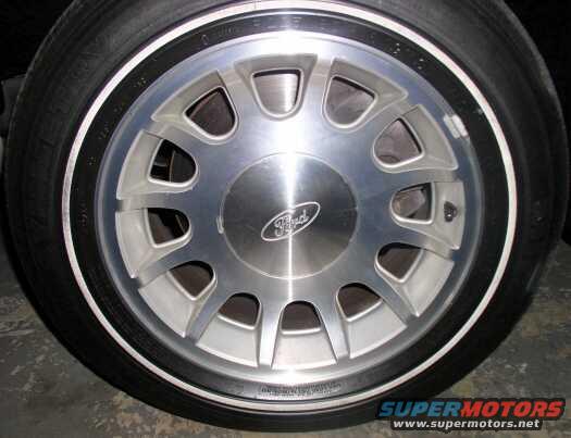 Close-up of a Ford wheel and tire. The wheel has a silver finish with a black stripe around the rim