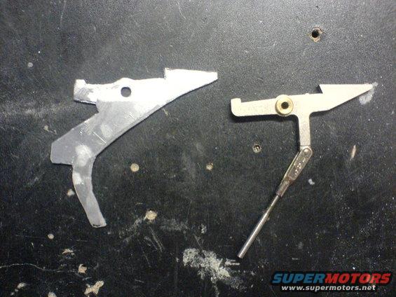 Two metal linkage parts on a dark surface