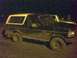 1993 Ford Bronco - A 1993 Ford Bronco is seen parked outdoors at night, with another vehicle partially visible behind it.