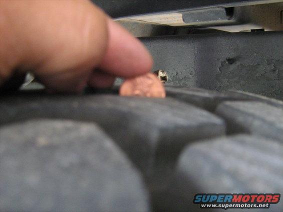 Penny on tire tread, close-up view of a vehicle's tire