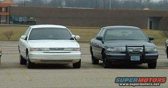 1998 Ford Crown Victoria and a dark police-style Crown Victoria parked