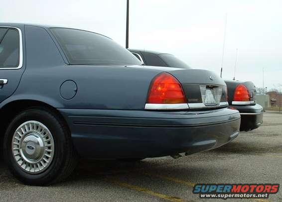 Rear quarter view of a blue Ford Crown Victoria, with another similar car behind it