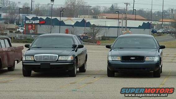 Two black Ford Crown Victorias parked in a lot, one with a chrome grille, the other with a black grille