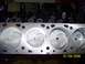 1995 Ford Bronco - Close-up view of an engine block's cylinder head mating surface and pistons.
