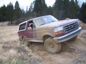 Maroon and tan 1992 Ford Bronco on a dirt hill, front-left angle