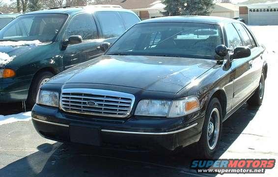 1998 Ford Crown Victoria front view, parked next to a green minivan