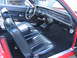 1973 Mercury Cougar - The interior of a red car shows black vinyl seats and a dashboard with 'COUGAR' badging, suggesting a model from the early 1970s.