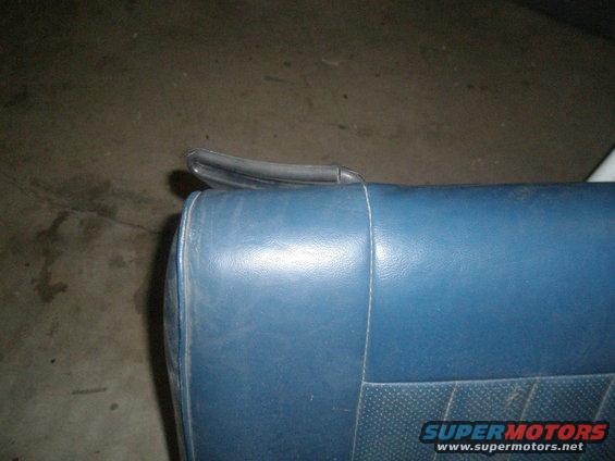 Close-up of a blue car seat with a black headrest handle