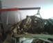 1999 Ford Mustang - An engine is suspended by chains and an engine hoist, being removed from a vehicle's engine bay.