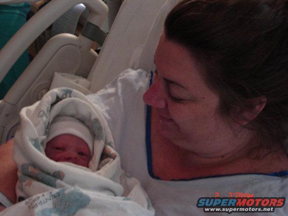 Newborn baby in blanket with woman