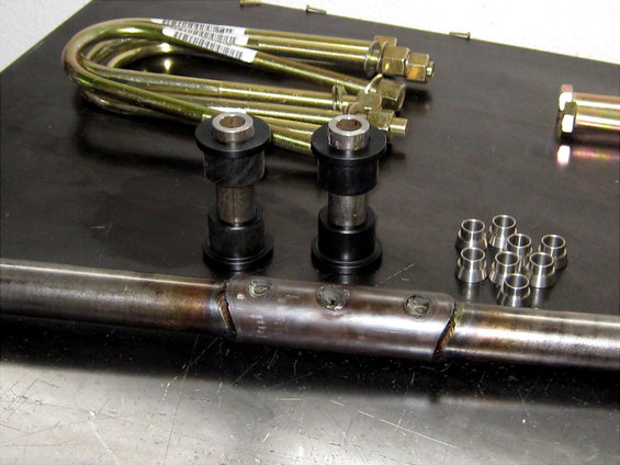 U-bolts, bushings, and metal sleeves on a workbench
