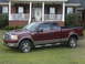 2005 Ford F-150 - Maroon 2005 Ford F-150 pickup truck parked on lawn in front of a residential house.