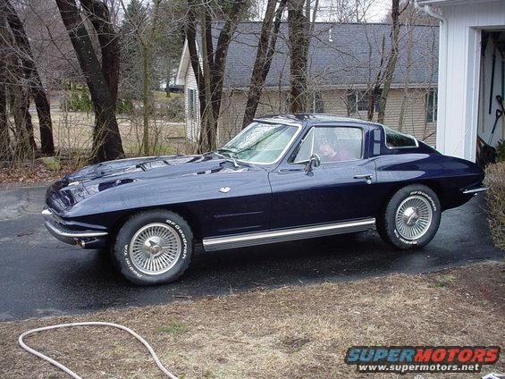 Dark blue coupe parked in driveway. Looks like a 1963 Corvette