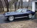 1964 Chevrolet Corvette - A dark blue coupe is parked in a driveway next to a garage.