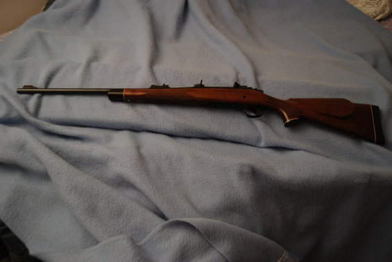 Wooden rifle with a long barrel resting on a blue blanket