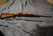 1991 Ford Bronco - A side view of a wooden rifle with a blued barrel and bolt action, laid out on a blue blanket.