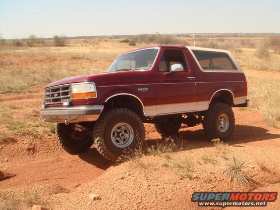 1992 Ford Bronco, red and white, off-roading on dirt trail