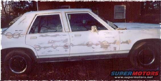 1991 Ford Crown Victoria side view, showing peeling white paint and some rust spots