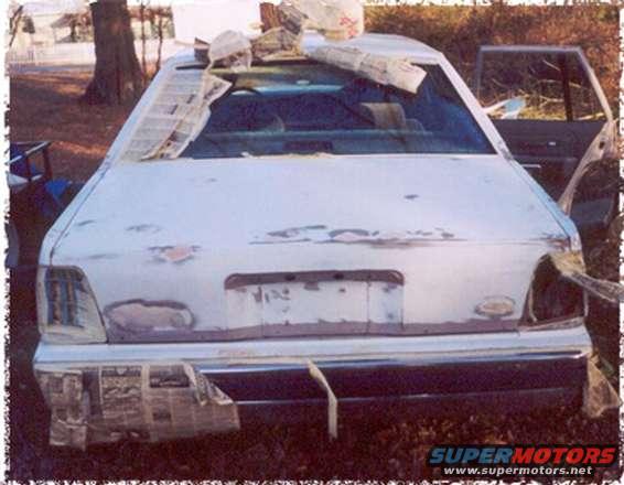 Rear of a white 1991 Ford Crown Victoria with newspaper in windows