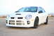 1996 Ford Probe - A white Dodge Neon SRT-4 is parked on a dirt lot under a clear sky.