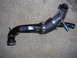 2007 Mazda 3 - A turbo intake pipe assembly is shown lying on a carpeted floor.