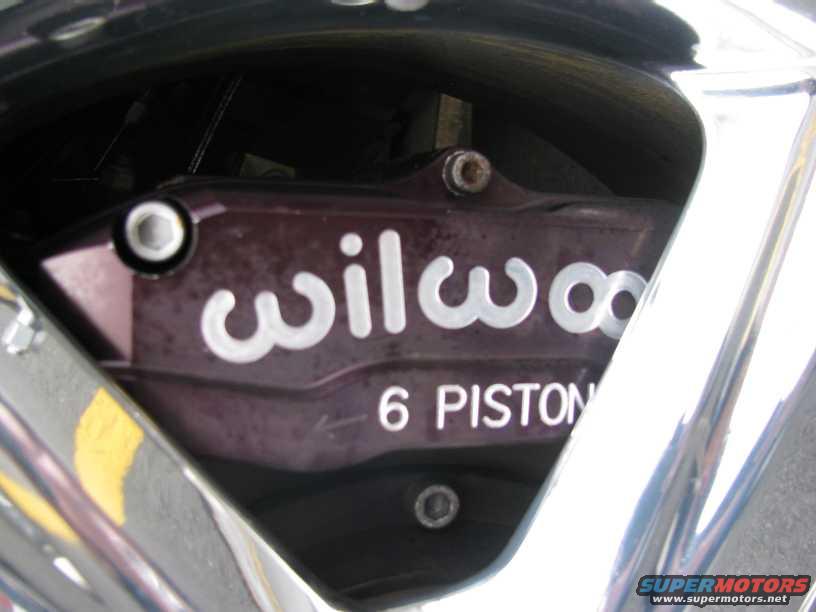 Purple Wilwood 6 piston brake caliper visible through a chrome wheel rim
