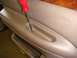 1996 Ford Bronco - Removing a screw from a vehicle's interior door panel with a screwdriver.