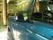 1996 Ford Bronco - A teal 1996 Ford Bronco is seen from the side in what appears to be a repair shop.