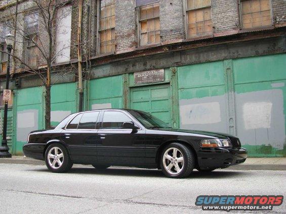 Black 2003 Mercury Marauder parked on street, side view, silver wheels, building in background