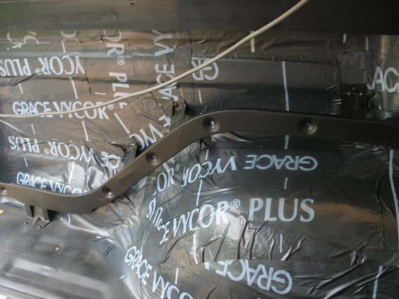 Vehicle interior with black soundproofing material labeled GRACE VYCOR PLUS and a dark metal trim piece