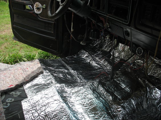 Car interior showing soundproofing material on the floor and door panel removed