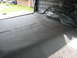 1978 Ford Bronco - The interior cargo area of a vehicle is being fitted with sound dampening material and carpet.