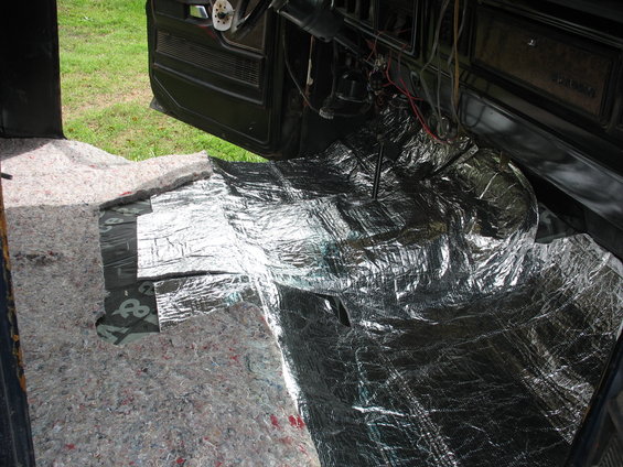 Interior floor of a vehicle with sound deadening material and carpet padding being installed