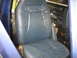 1978 Ford Bronco - The interior of a vehicle shows worn blue leather seats and exposed soundproofing material on the rear floor and walls.