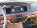 1995 Mercury Grand Marquis - The dashboard of a car features an aftermarket stereo and climate controls, with wood grain trim around the center console.