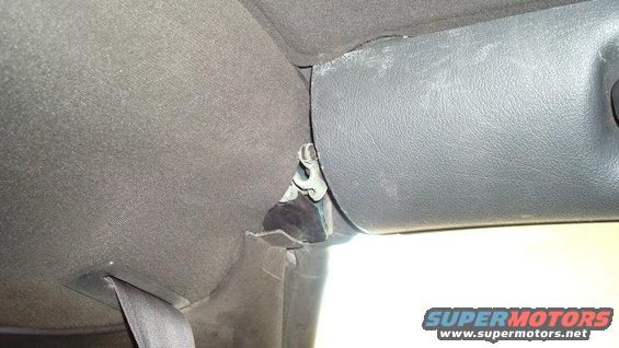 Close-up of car's interior trim panel and seatbelt anchor