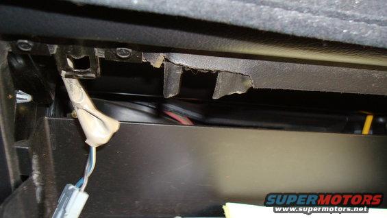 Interior trim panel with exposed wiring and damaged clips