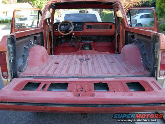 Interior and bed of a stripped-down pickup truck, showing dashboard and open tailgate