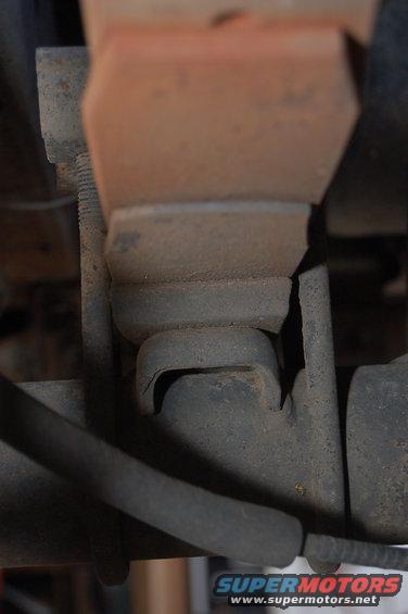 Close-up of a rusty suspension component with a rubber bushing