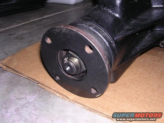 Close-up of a black differential housing with a bolted flange and a nut