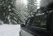 1993 Ford Bronco - A black Ford Bronco is parked on a snowy road surrounded by snow-covered pine trees.