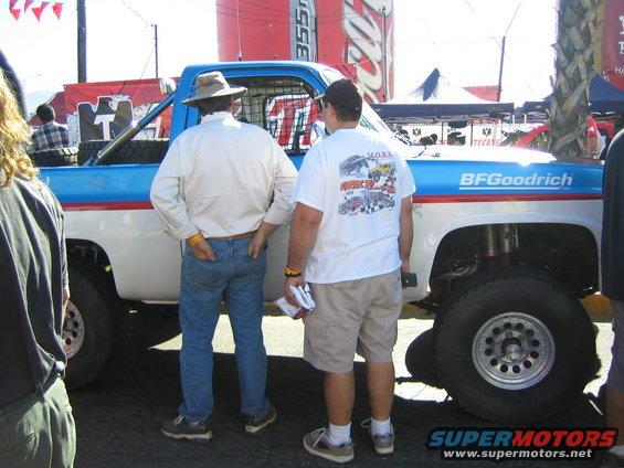 Off-road race truck with BFGoodrich branding, two men standing next to it