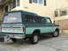 1979 Ford F-150 - This 1979 Ford F-150 pickup truck features a distinctive two-tone paint scheme and a camper shell, viewed from the rear.