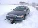 1999 Ford Crown Victoria - Sedan stuck in deep snow, showing front grille and headlights.