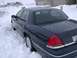 1999 Ford Crown Victoria - A dark blue sedan is partially buried in snow on a residential street.