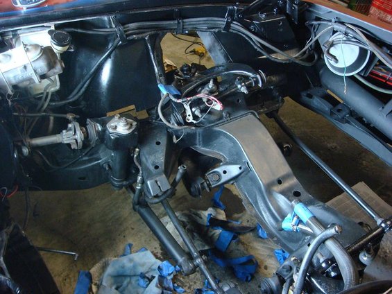 Car frame with steering rack, brake master cylinder, and suspension components visible