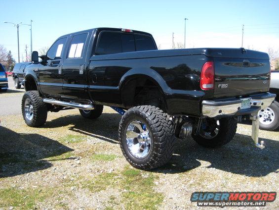 Black lifted Ford F-350 pickup truck, rear 3/4 view. F-350 badge visible