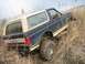 1990 Ford Bronco - This Ford Bronco appears to be stuck in a field of dry grass and mud.