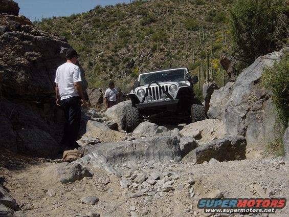 Front view of a white 2004 Jeep Wrangler on a rocky desert trail