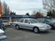 1987 Ford Crown Victoria LTD - A silver sedan is parked in a lot next to other vehicles. The car's body style suggests a 1990s model year.